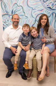 Happy family of four at Ocean City Moms event with colorful mural background.
